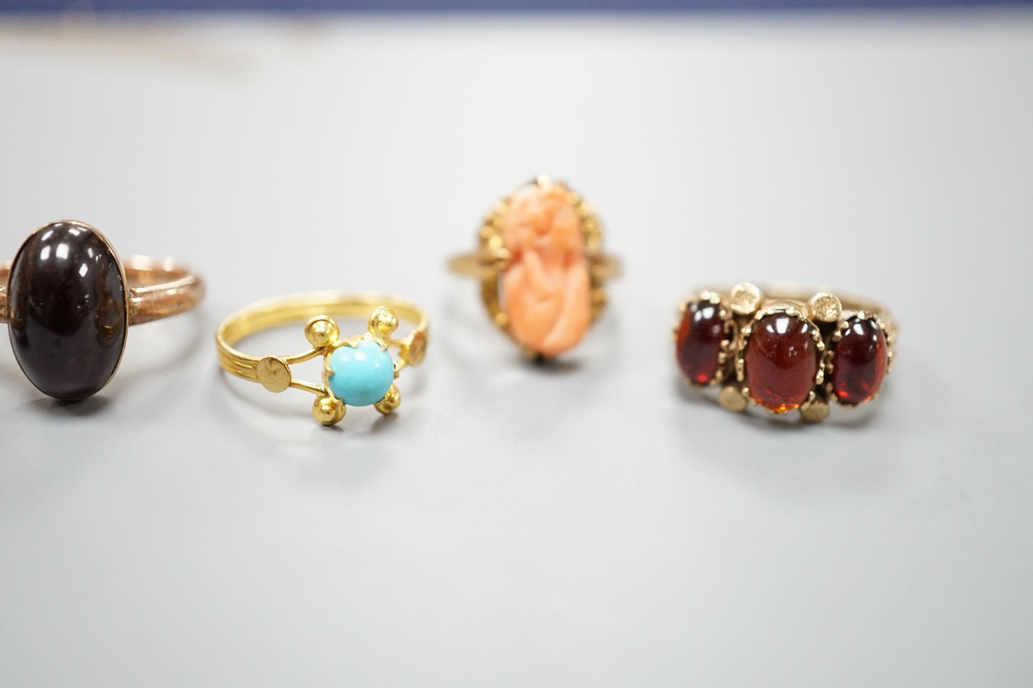 Three assorted modern 9ct gold and gem set ring including turquoise and seed pearl, gross 11.2 grams, a 10k and coral set ring, gross 2.7 grams and a yellow metal and turquoise set ring, gross 1.3 grams.